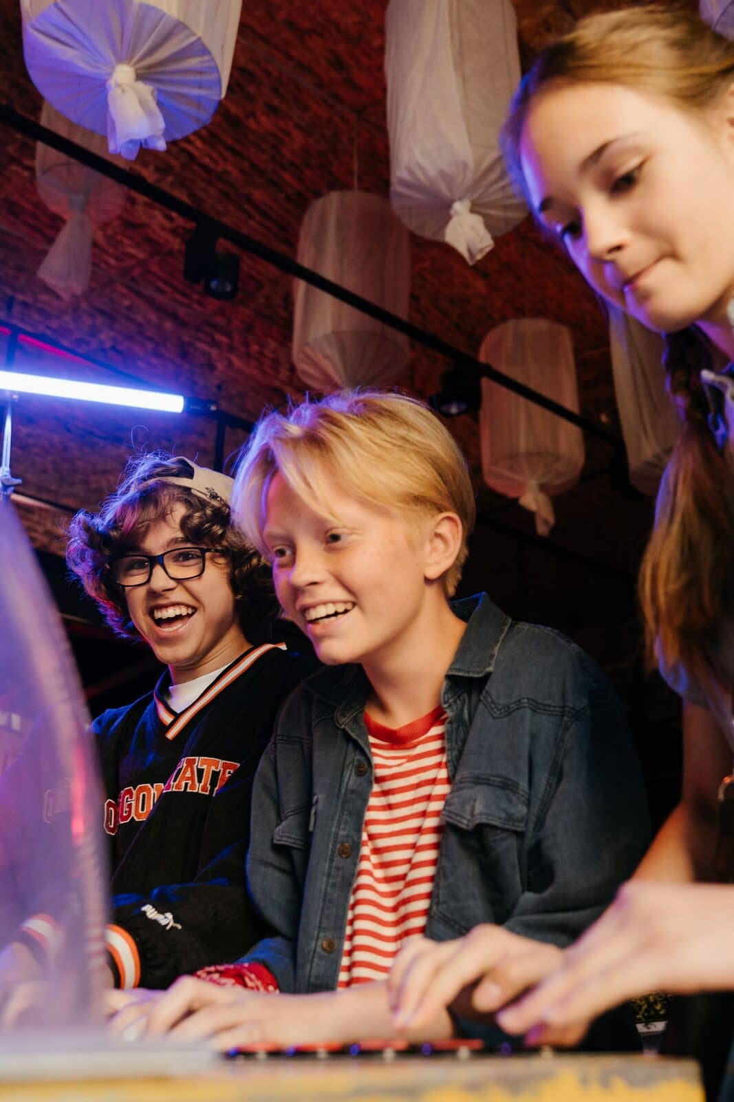 Friends laughing while playing arcade games
